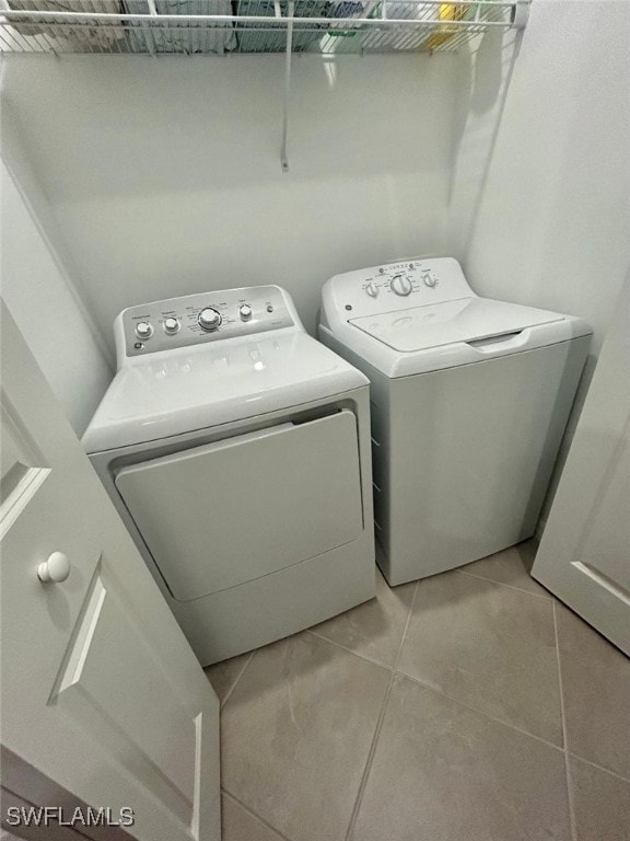 washroom featuring light tile patterned floors and washing machine and clothes dryer