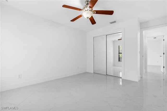 unfurnished bedroom with ceiling fan and a closet