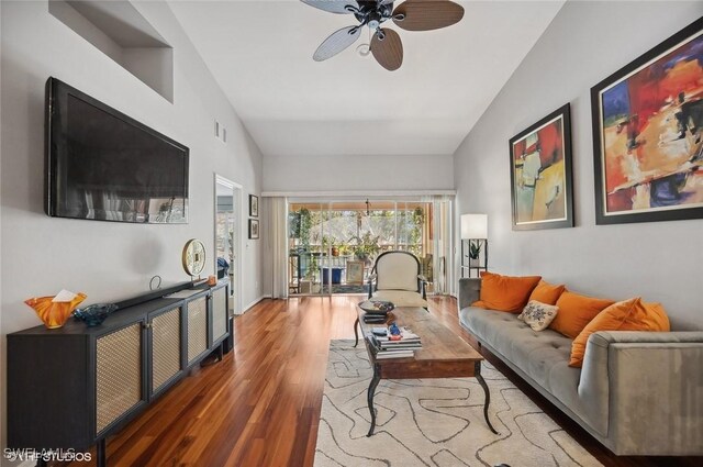 living room with lofted ceiling, ceiling fan, wood-type flooring, and a fireplace