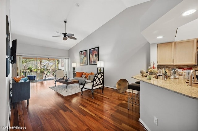 living room featuring lofted ceiling, dark wood-type flooring, sink, and ceiling fan