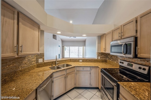 kitchen with light tile patterned floors, appliances with stainless steel finishes, light stone counters, light brown cabinets, and a sink