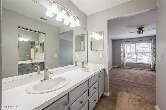 bathroom featuring a sink, baseboards, and double vanity