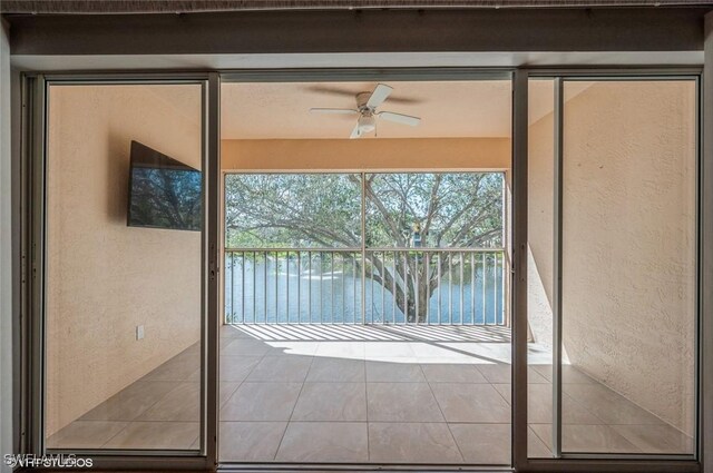 doorway featuring ceiling fan and a water view