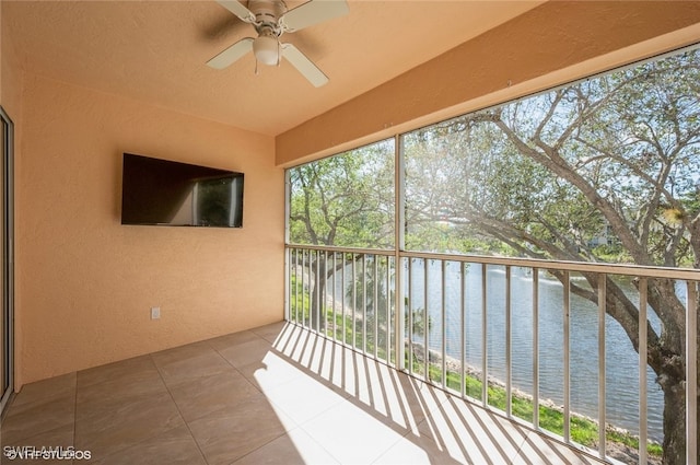 unfurnished sunroom with plenty of natural light and a ceiling fan