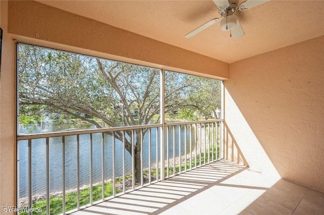 balcony featuring a water view and ceiling fan