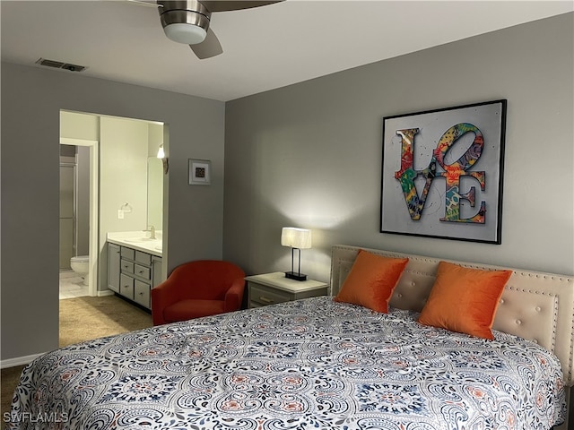 bedroom featuring sink, ensuite bath, light colored carpet, and ceiling fan