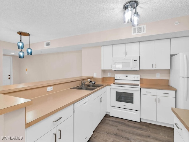 kitchen featuring a textured ceiling, dark hardwood / wood-style floors, white appliances, hanging light fixtures, and sink