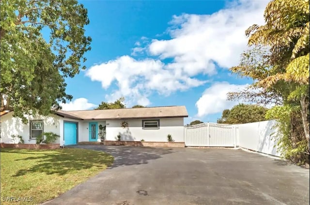 1797 42nd Ter SW, Naples, FL 34116 - ranch-style house with a gate, asphalt driveway, an attached garage, a front lawn, and stucco siding