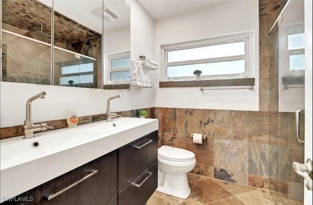 1797 42nd Ter SW, Naples, FL 34116 - bathroom with tile walls, a stall shower, vanity, toilet, and plenty of natural light
