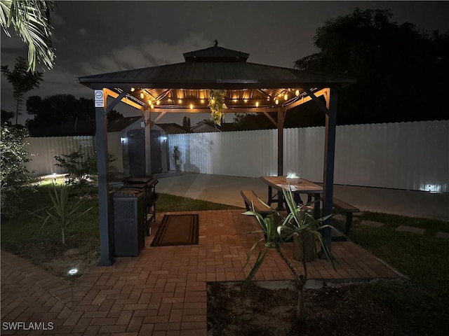1797 42nd Ter SW, Naples, FL 34116 - patio at night with a gazebo and a fenced backyard