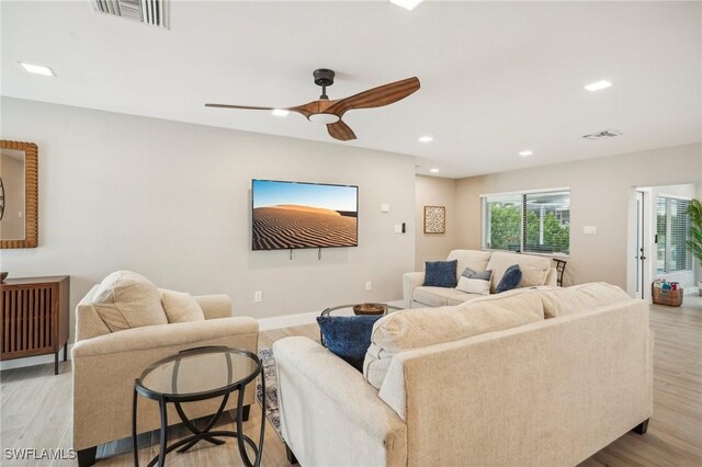 living room featuring light hardwood / wood-style flooring and ceiling fan