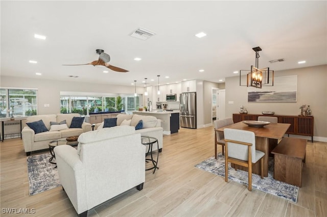 8339 Estero Blvd, Fort Myers Beach, FL 33931 - living room featuring recessed lighting, visible vents, ceiling fan with notable chandelier, and light wood-style floors