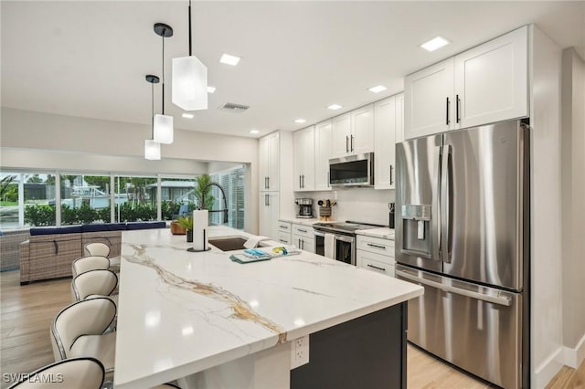 8339 Estero Blvd, Fort Myers Beach, FL 33931 - kitchen with visible vents, appliances with stainless steel finishes, white cabinets, and a breakfast bar
