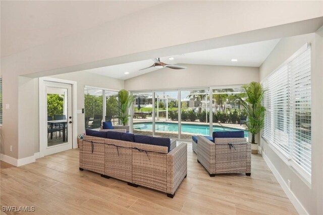 living room with plenty of natural light, ceiling fan, light wood-type flooring, and vaulted ceiling