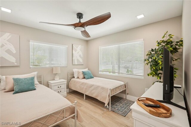 bedroom with multiple windows, light hardwood / wood-style flooring, and ceiling fan