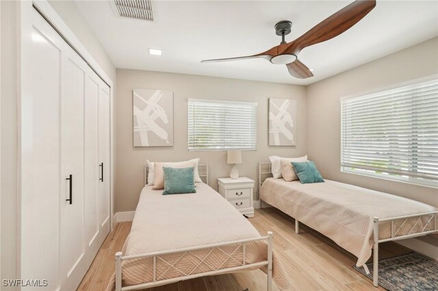 bedroom featuring light wood-type flooring, a closet, and ceiling fan