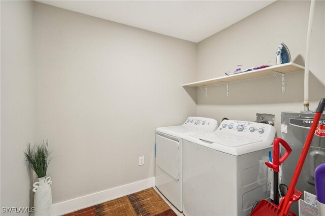 laundry room with dark hardwood / wood-style flooring, washer and clothes dryer, and water heater