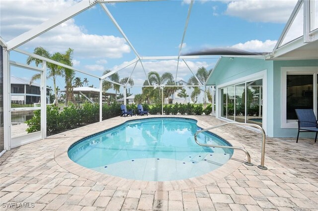 view of swimming pool with a lanai and a patio