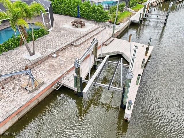 dock area with a patio and a water view