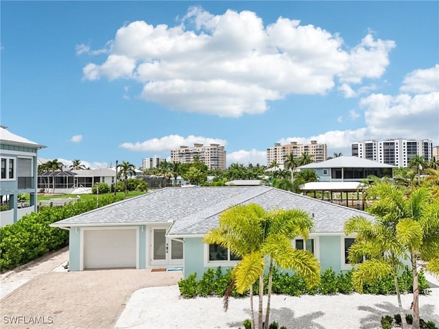 8339 Estero Blvd, Fort Myers Beach, FL 33931 - view of front of house featuring stucco siding, decorative driveway, a garage, and roof with shingles
