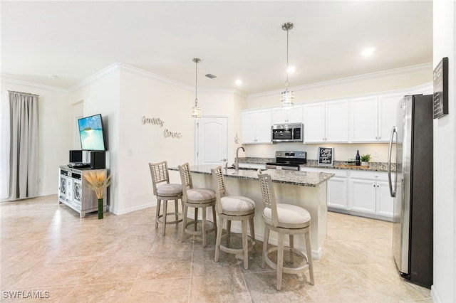 kitchen with stone countertops, a center island with sink, white cabinets, appliances with stainless steel finishes, and decorative light fixtures