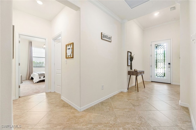 foyer featuring ornamental molding, light tile patterned flooring, visible vents, and baseboards