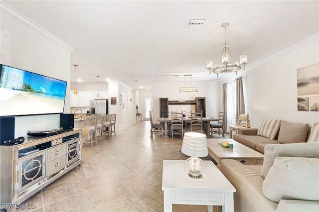 living room with light tile patterned floors, ornamental molding, visible vents, and an inviting chandelier