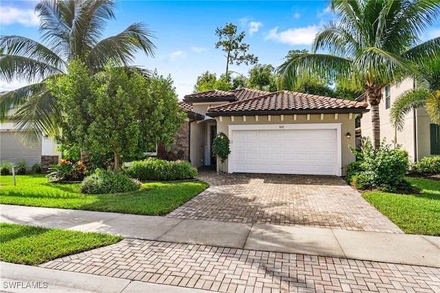 mediterranean / spanish-style home with a garage, a tiled roof, decorative driveway, and stucco siding