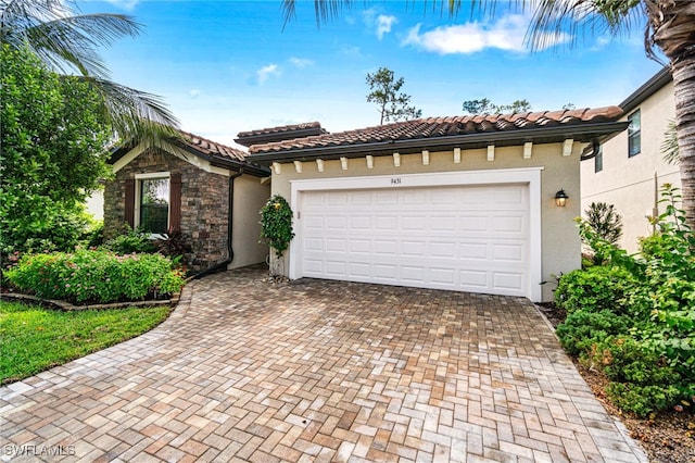 view of front of property featuring a garage, decorative driveway, stone siding, and stucco siding