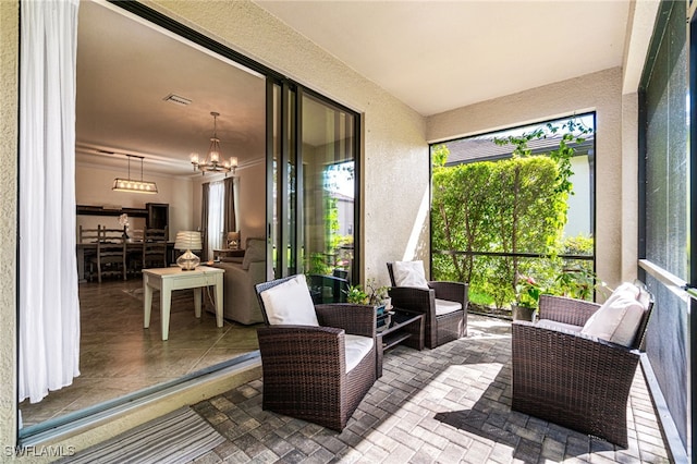 sunroom featuring an inviting chandelier and visible vents