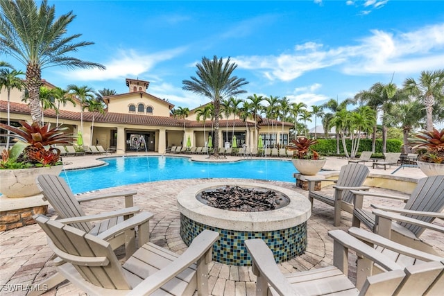 pool featuring an outdoor fire pit and a patio area