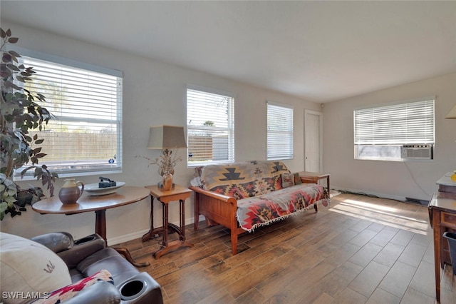 living room featuring cooling unit, baseboards, and wood finished floors