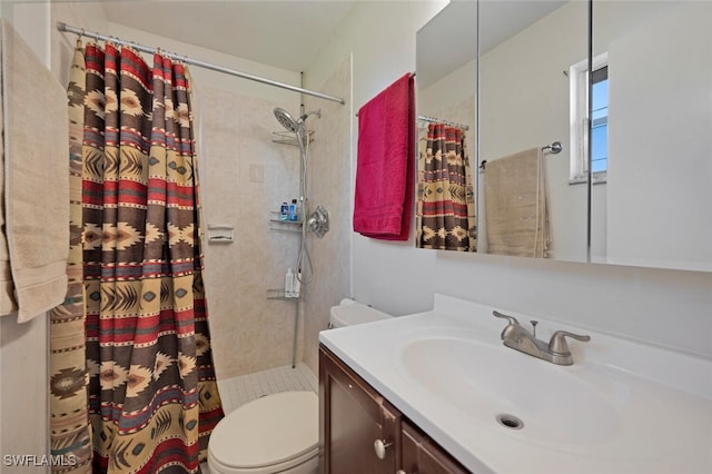 full bathroom featuring toilet, tiled shower, and vanity