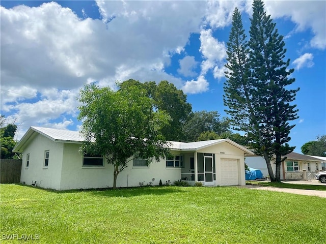 single story home with metal roof, a garage, fence, driveway, and a front yard