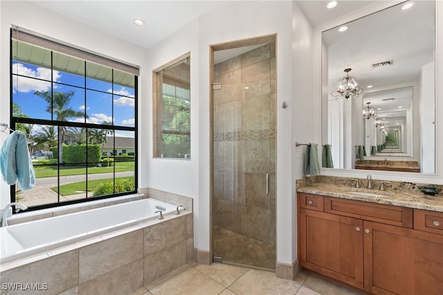 bathroom with tile patterned floors, shower with separate bathtub, an inviting chandelier, and vanity