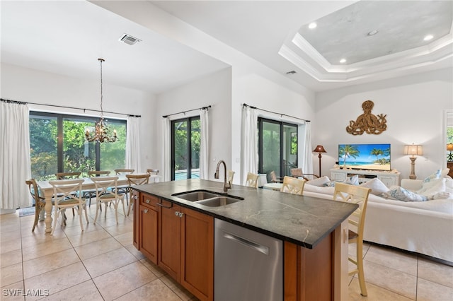 kitchen with a center island with sink, stainless steel dishwasher, sink, and plenty of natural light