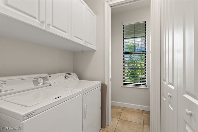 laundry area with light tile patterned floors, cabinets, and washer and dryer