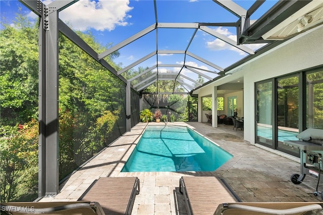 view of swimming pool with glass enclosure and a patio