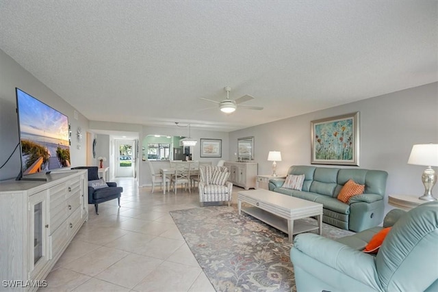 tiled living room with ceiling fan and a textured ceiling