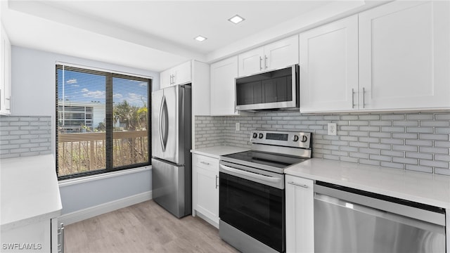 kitchen with backsplash, light hardwood / wood-style floors, white cabinetry, and stainless steel appliances