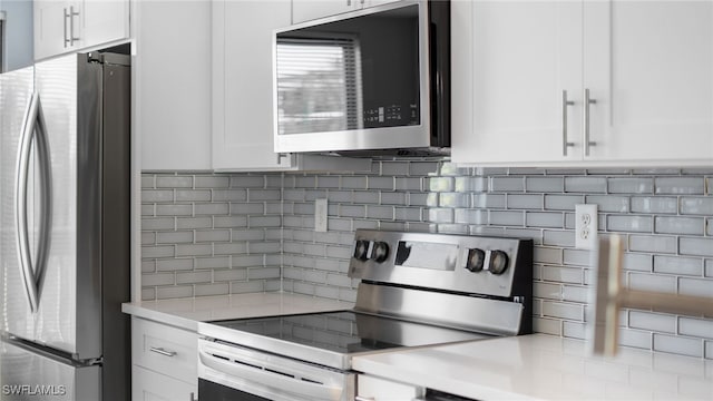 kitchen featuring appliances with stainless steel finishes, tasteful backsplash, and white cabinetry