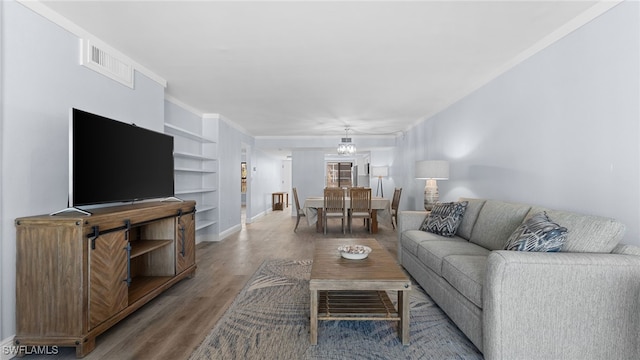 living room with hardwood / wood-style floors and a notable chandelier