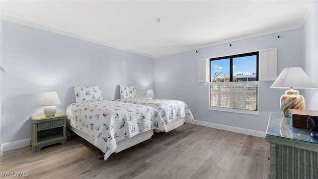 bedroom featuring wood-type flooring and ornamental molding