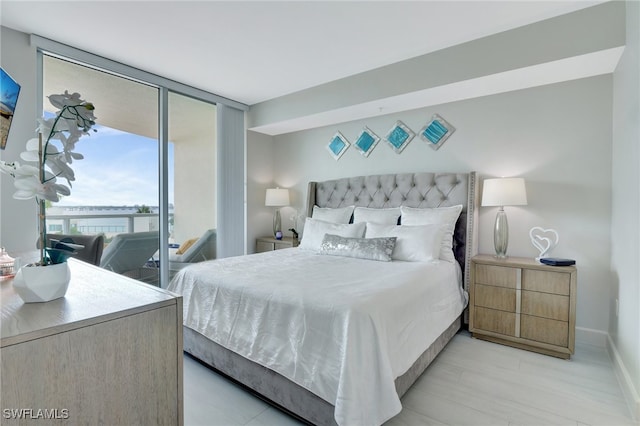 bedroom with light hardwood / wood-style flooring and floor to ceiling windows