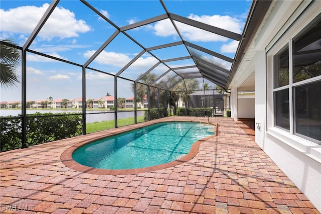 view of swimming pool featuring a lanai, a patio area, and a water view