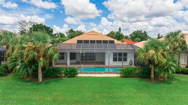 rear view of house with a lawn, a patio, and glass enclosure