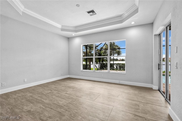 unfurnished room with crown molding and a raised ceiling