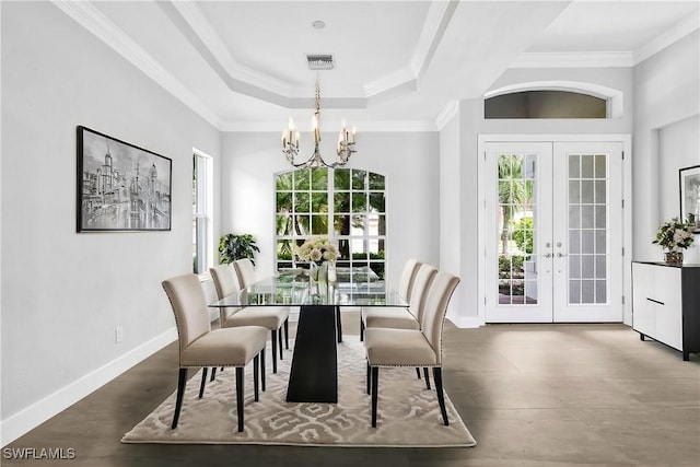 dining area with a notable chandelier, crown molding, french doors, and a raised ceiling