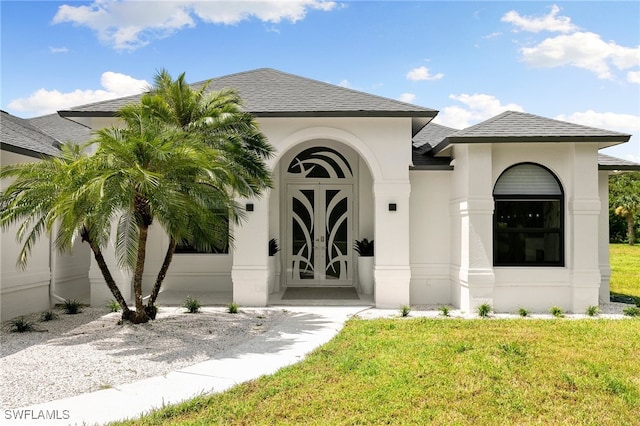 property entrance featuring a yard and french doors