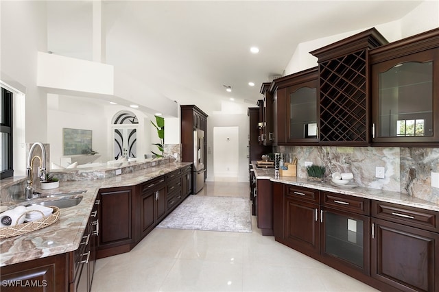 bathroom featuring decorative backsplash, vanity, high vaulted ceiling, and tile patterned floors